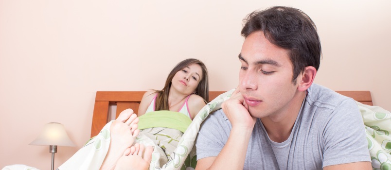 Couple laying in bed bored