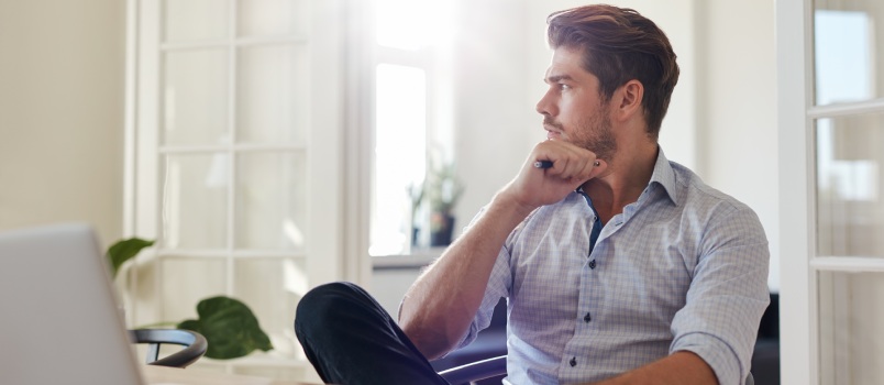 Young man sitting on table looking outside