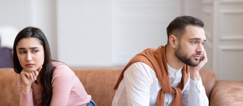 Unhappy couple sitting on couch
