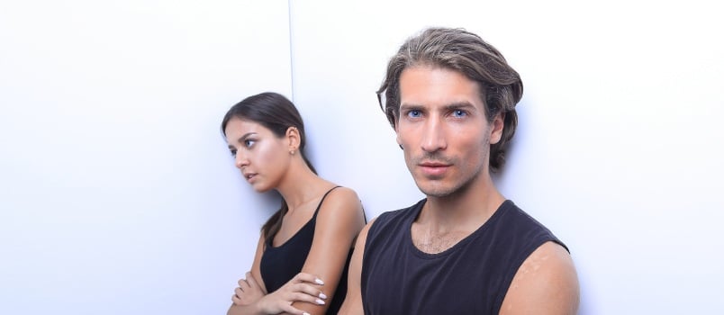 Couple standing near white wall