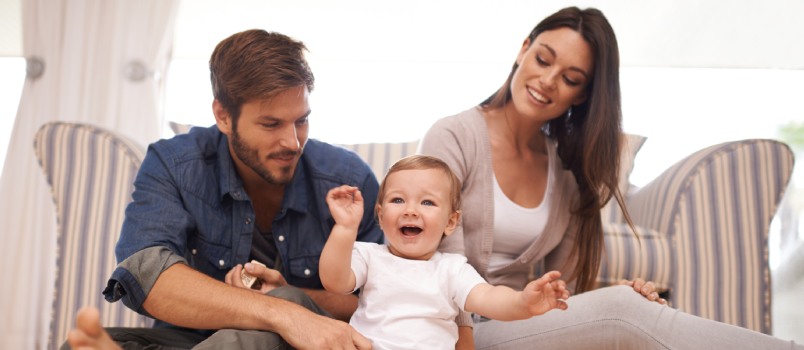 Young couple at home playing with their baby