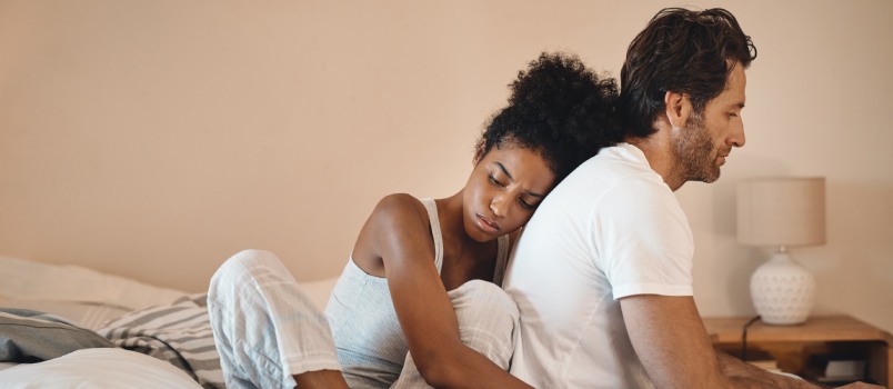 Woman hugging frustrated sad man from back