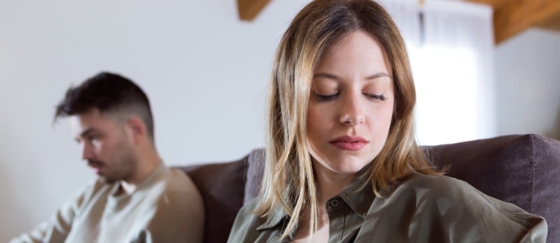 Angry young couple sitting on couch