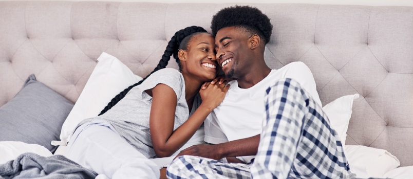 Happy couple sitting on bed