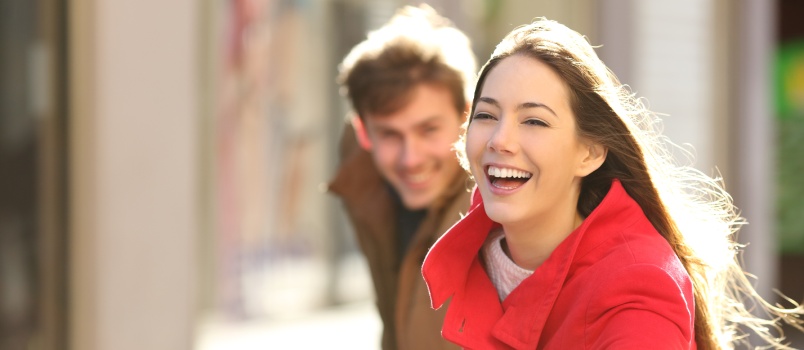 Happy couple running on street