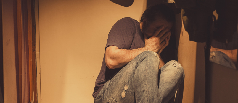 Sad scared man sitting in corner