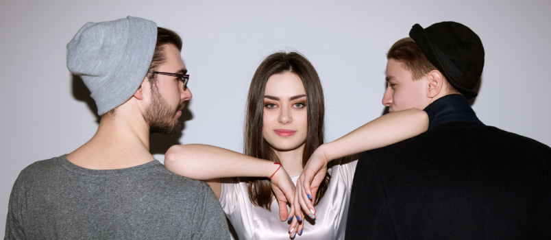 Guys looking at women while she is looking at camera