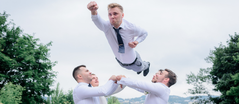 Best man dressed formal attires throwing groom