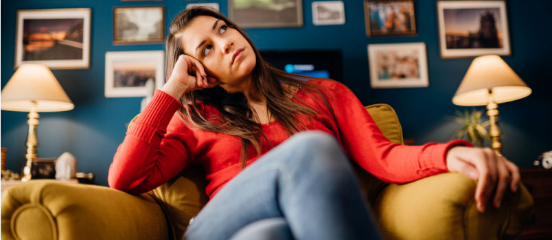 Alone women thinking sitting on couch