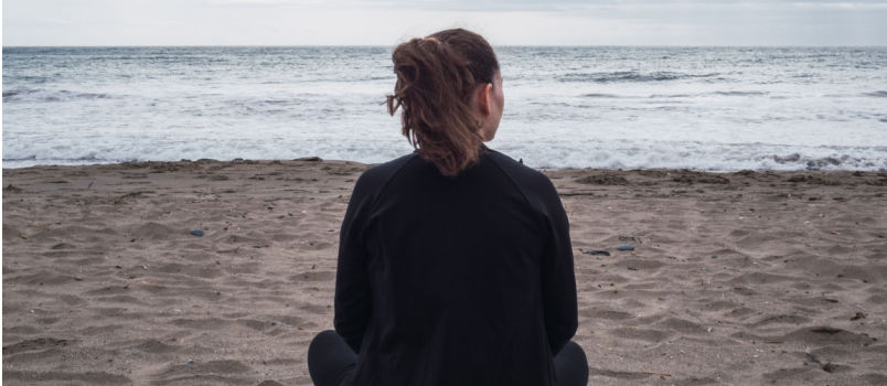 Women sitting alone on beach