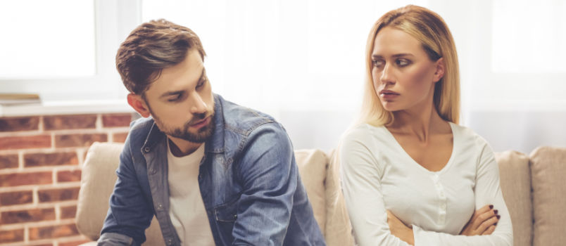 Beautiful couple sitting back to back on couch