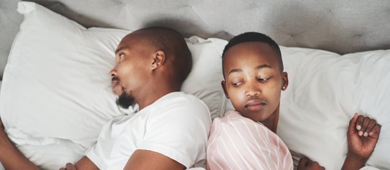Young couple ignoring each other in bed