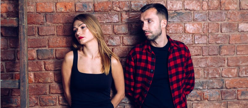Young couple standing leaning on the wall
