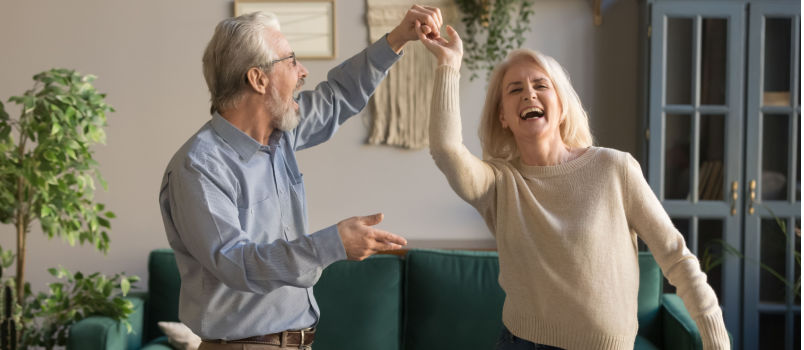 Joyful couple dancing at home