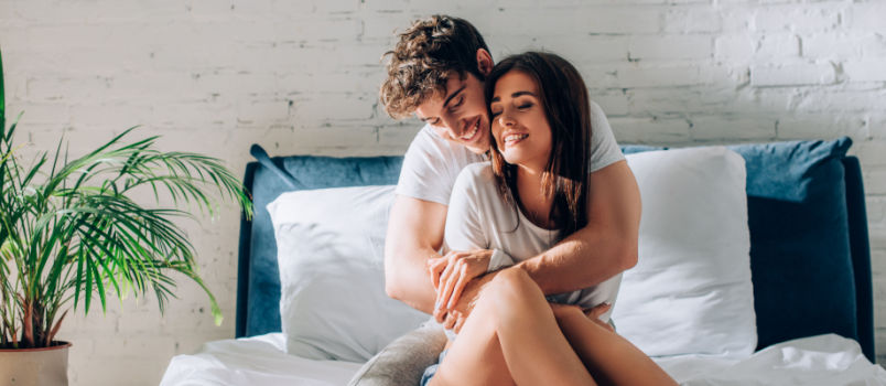 young couple looking at each other on bed