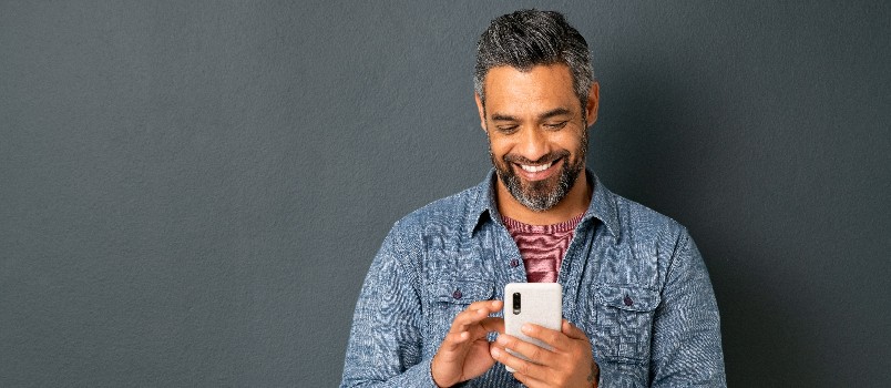 Man smiling while using smartphone