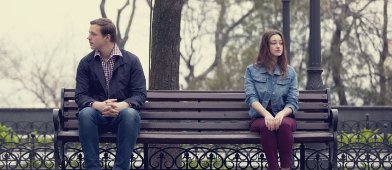 Couple sitting on bench apart