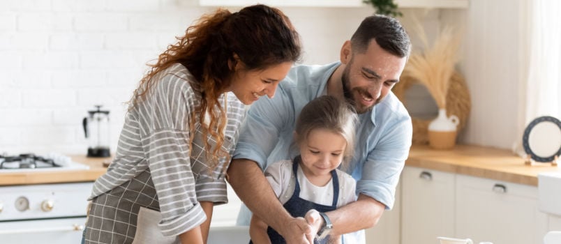 Small kid preparing pie with parents