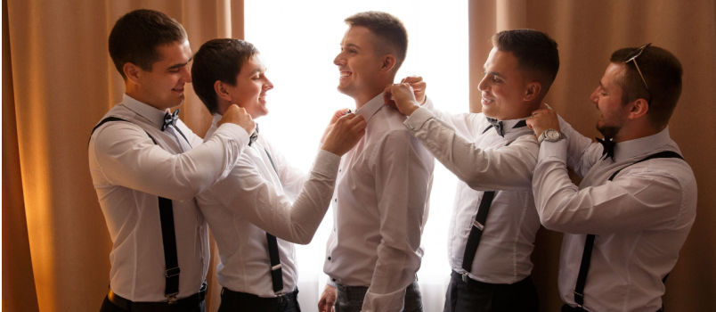 Groomsman helping groom