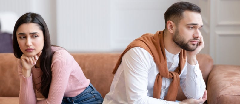 Unhappy couple sitting on couch