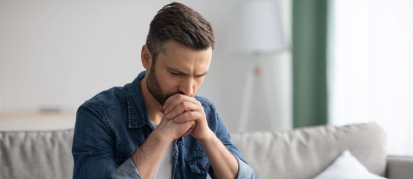 Upset man sitting on couch