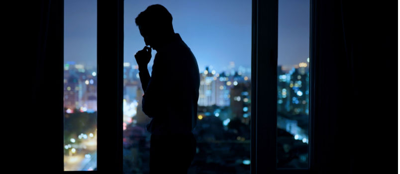 Sad man standing near the wall