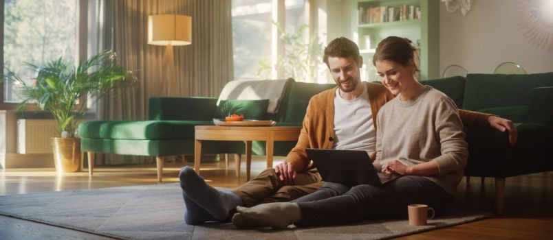 Happy couple working on laptop