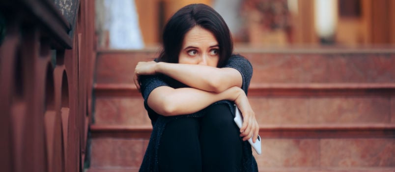 Sad woman sitting alone on stairs