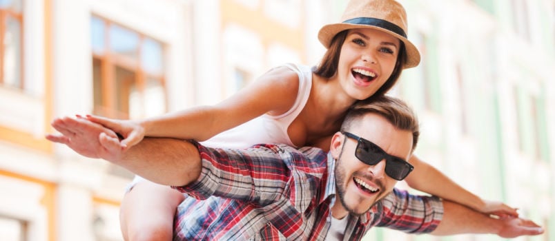 Happy loving couple young man piggybacking woman