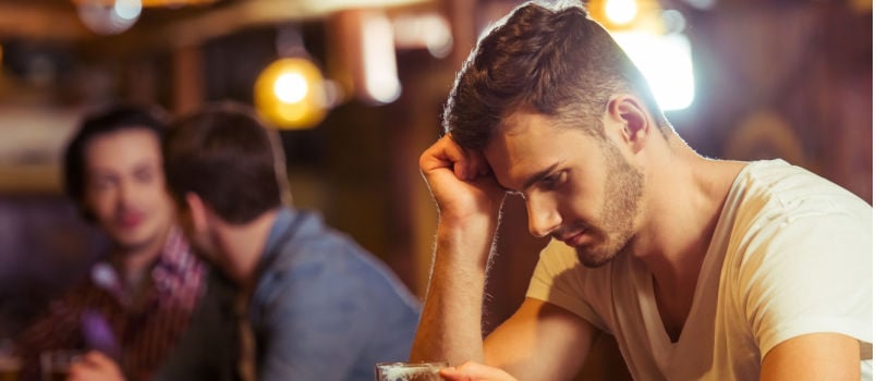 Sad man having beer in club