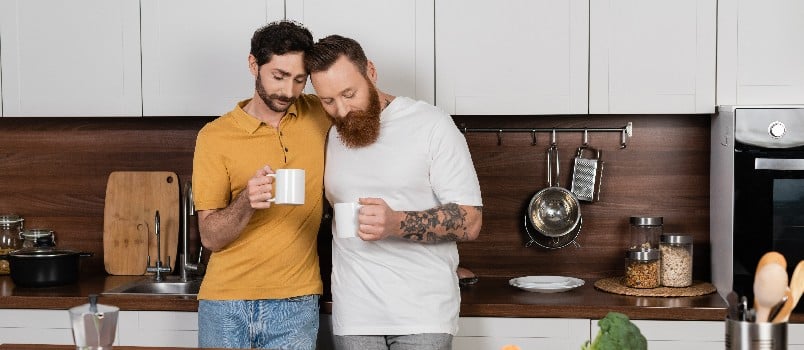 Gay couple holding coffee mug