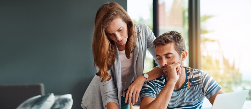 Couple reading documents on laptop