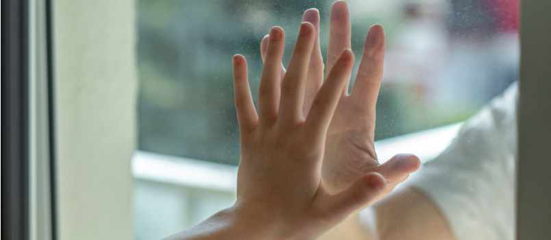 Separated hand by glass wall