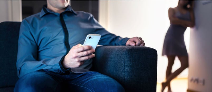 Jealous man looking at wife phone