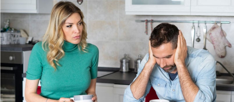 Serious woman looking at worried boyfriend