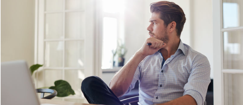 Young man sitting on chair looking outside of the window