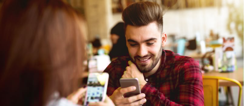 Couple using phone in cafe
