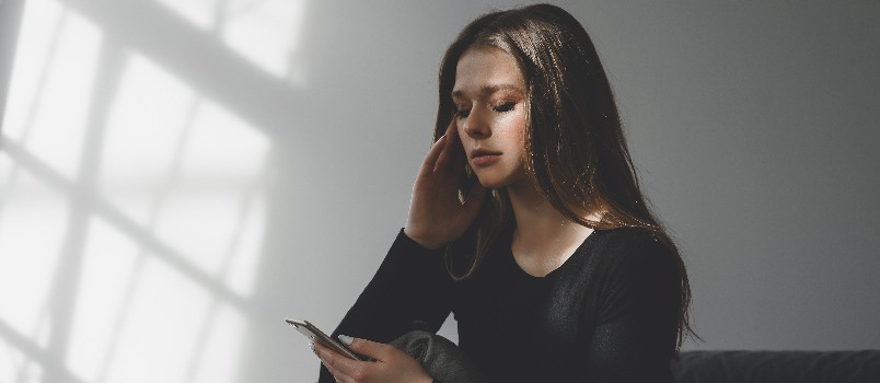 Sad crying woman using smartphone