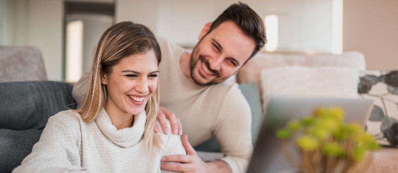 Happy couple using laptop
