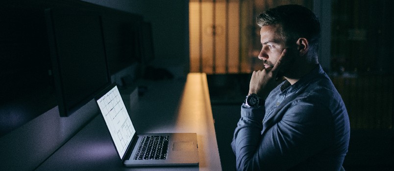 Young businessman looking at laptop being depressed