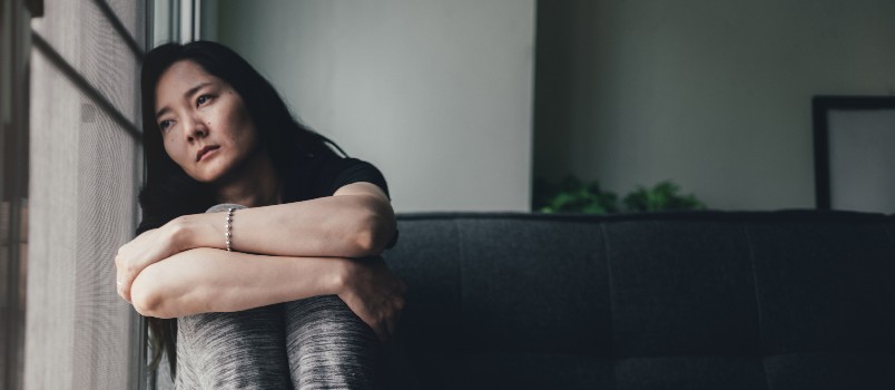 Sad thoughtful woman sitting alone