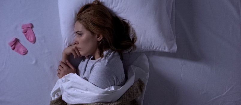 Sad lady crying laying on bed