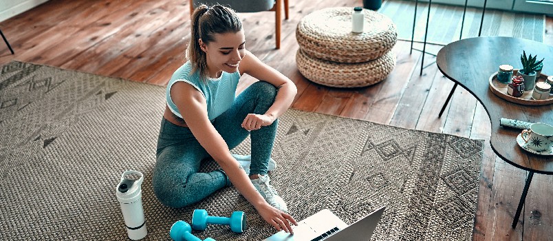 Sports woman sitting on floor working