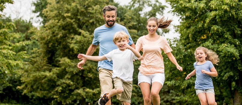 Family playing soccer together in garden