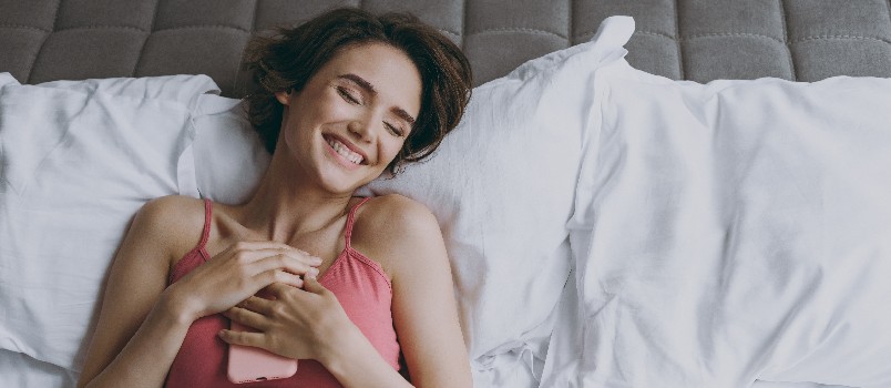 Satisfied young woman laying on bed
