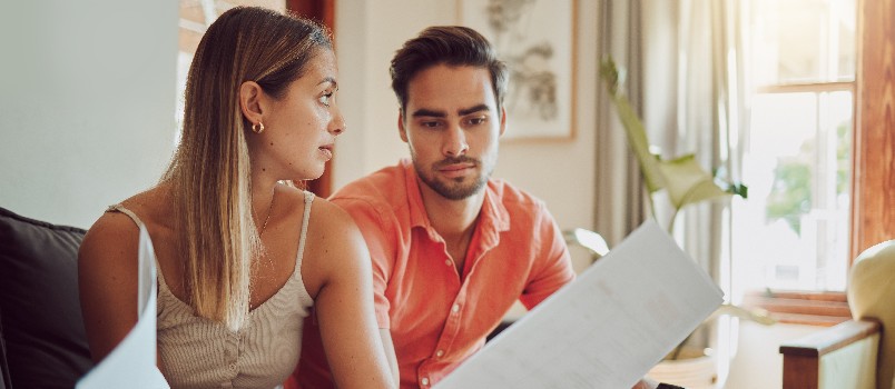 Unhappy stressed couple playing their bills