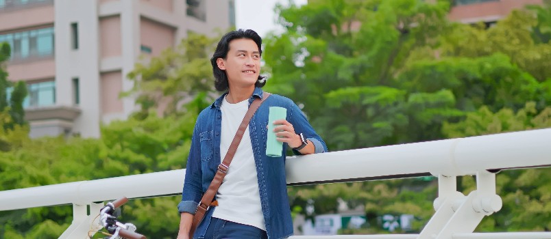 Asian man standing beside his bike