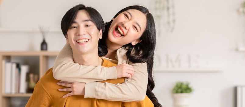 young woman hugging man from back