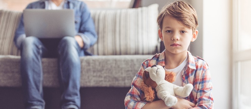 Sad boy holding teddy bear 