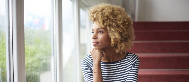 Young woman looking outside window